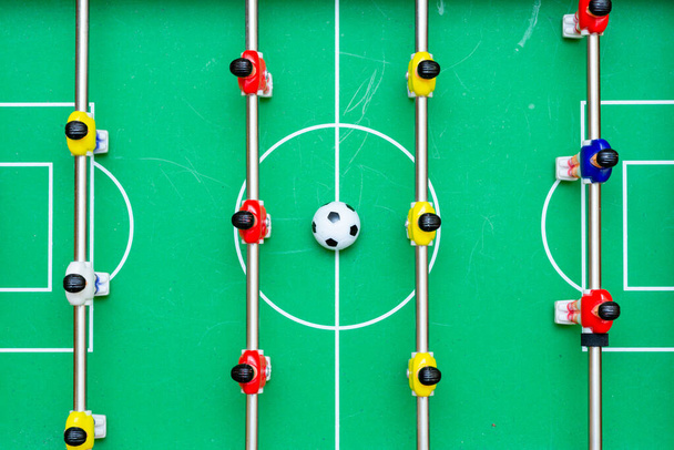 Вид зверху настільний футбол з червоними жовтими гравцями і м'ячем
. - Фото, зображення