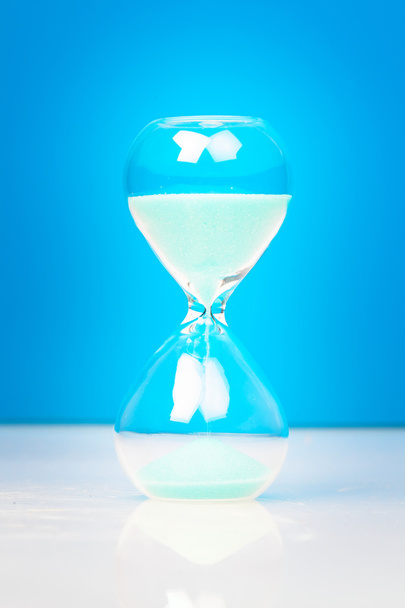 Hourglass with blue sand - 写真・画像