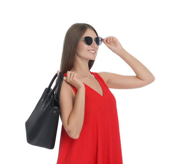 Jovem mulher vestindo elegante vestido vermelho com saco elegante no fundo branco - Foto, Imagem