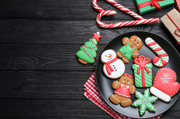 Delicious Christmas cookies on black wooden table table, flat lay. Space for text - Photo, image