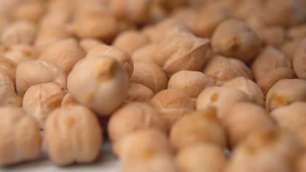 Uncooked dried chickpeas fall in a heap close up. Fresh raw legumes. Cicer arietinum. Macro shot. Falling - Záběry, video