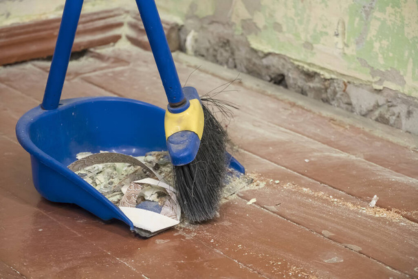 修理の後は片づけなさい。ダストパンにブラシで建設土石流を掃引.家で汗をかく。家を掃除するためのツール。家の修理だ。改装後のほこりや破片. - 写真・画像