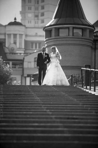 Bride and groom walking down the stairs at city - Photo, Image