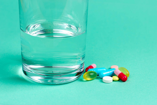 Vitamins, pain pills, antibiotics and a glass of water. Pharmaceuticals - Фото, изображение