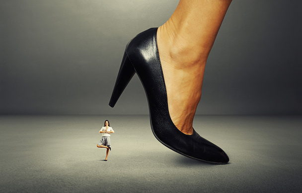 business woman under big heel over dark
 - Фото, изображение