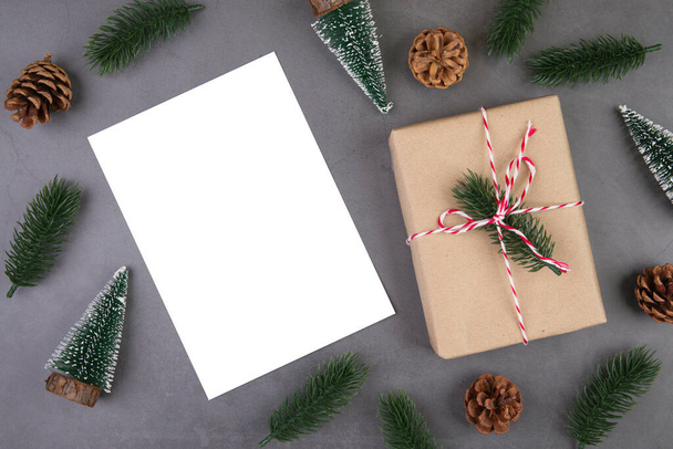 Kerstvakantie compositie met geschenkdoos decoratie en wenskaart, nieuwjaar en Kerstmis of verjaardag met geschenken en ansichtkaart op cementvloer achtergrond, bovenaanzicht of platte lay, kopieerruimte. - Foto, afbeelding