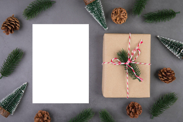 Christmas holiday composition with gift box decoration and greeting card, new year and xmas or anniversary with presents and postcard on cement floor background, top view or flat lay, copy space. - Photo, Image