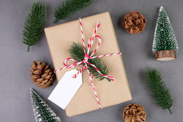 Christmas holiday composition with gift box having label decoration, new year and xmas or anniversary with presents having tag on cement floor background in season, top view or flat lay, copy space. - Photo, Image