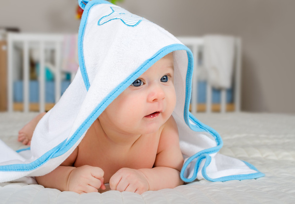 Lindo bebé niño en una toalla con capucha después del baño
 - Foto, imagen