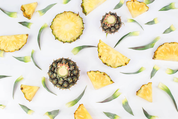 einzelne ganze Ananas. in Scheiben geschnittene Ananas in exotischen Sommer Obst Design weißer Hintergrund Draufsicht Attrappe. - Foto, Bild