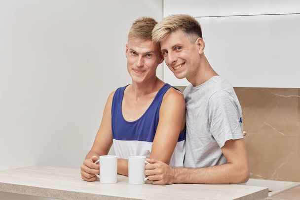 Cute gay couple drinking coffee in the morning. They look at the camera. - Foto, immagini