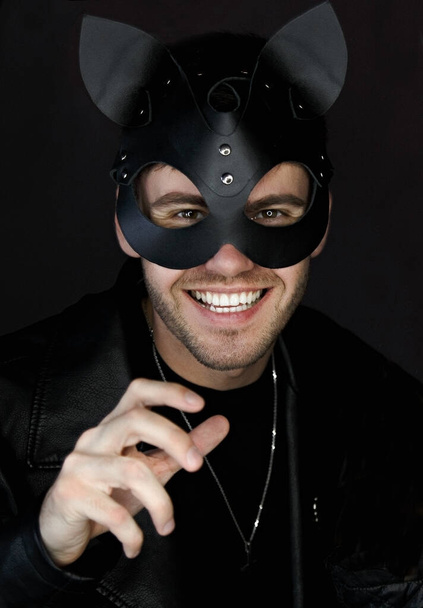 Человек в кожаной маске кота, улыбающийся - Фото, изображение