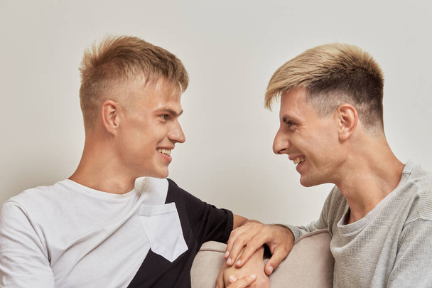 Happy gay couple spend time together, talking and smiling, holding hands. - Valokuva, kuva