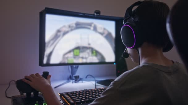 Niño jugando un simulador de vuelo con auriculares - Metraje, vídeo