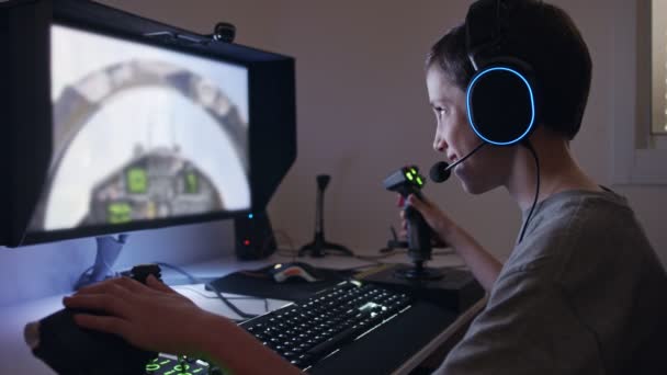 Młody chłopiec gra na symulatorze lotu w słuchawkach - Materiał filmowy, wideo