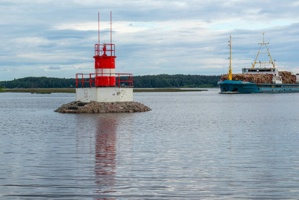 vodoznak na přírodní nádrži, moře indikující nebezpečí a nákladní loď poblíž břehu proti krásné obloze - Fotografie, Obrázek