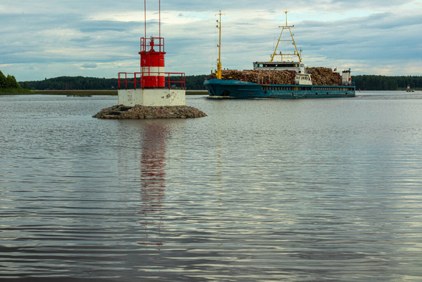 water sign on a natural reservoir, sea to indicate danger and a cargo ship near the shore against a beautiful sky - Zdjęcie, obraz