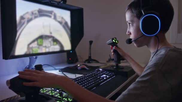 Giovane ragazzo che gioca un simulatore di volo indossando un auricolare - Filmati, video