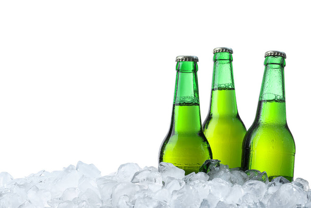 Bottles of beer on ice cubes against white background - Φωτογραφία, εικόνα