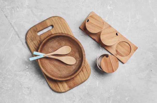 Wooden cooking utensils on grey marble table, flat lay - Fotó, kép