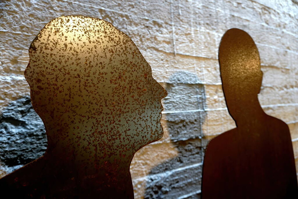 Twee roestige metalen platen als menselijk silhouet op een ruwe betonnen ondergrond. Twee mensen silhouet.                                - Foto, afbeelding