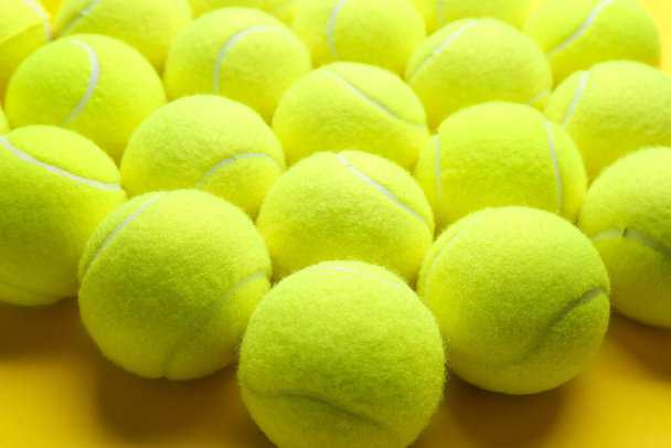 Tennis balls on yellow background, closeup. Sports equipment - Fotoğraf, Görsel