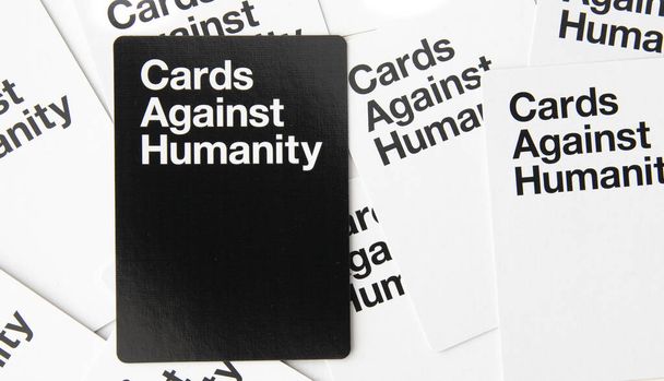 Adult κόμμα κάρτες παιχνίδι κατά της ανθρωπότητας διάσπαρτα λευκά και μαύρα χαρτιά - Φωτογραφία, εικόνα