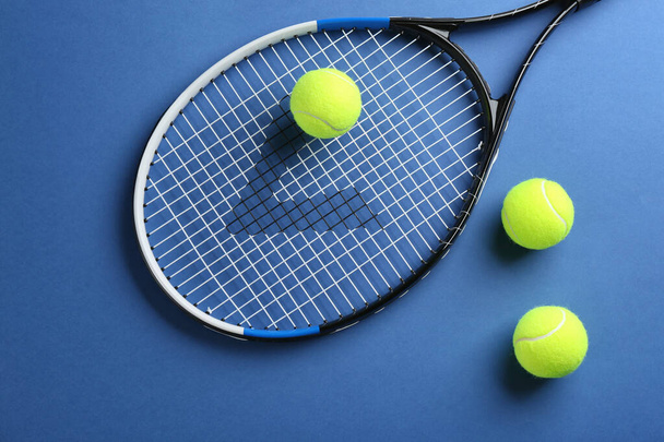 Tennis racket and balls on blue background, flat lay. Sports equipment - 写真・画像