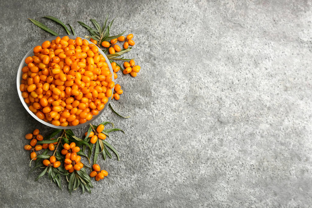 Fresh ripe sea buckthorn on grey table, flat lay. Space for text - Foto, Bild