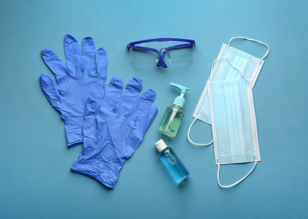 Flat lay composition with medical gloves, masks and hand sanitizers on blue background - Zdjęcie, obraz