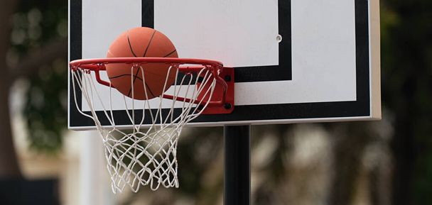 いいバスケットボールだな。バスケットボールボールがバスケットボールの輪に飛び込む。屋外バスケットボールコート. - 写真・画像