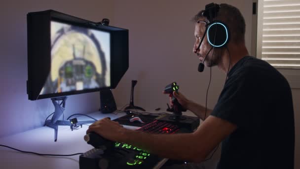Egy férfi, aki repülőgép szimulátort játszik a számítógépen, fejhallgatót visel. - Felvétel, videó