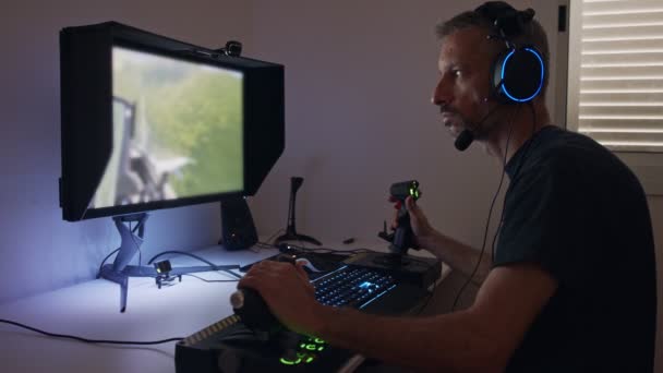 Человек, играющий симулятор полета на компьютере, одетый в наушники - Кадры, видео