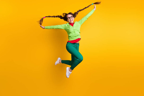 Full length body size view of nice funky crazy carefree childish cheerful girl jumping having fun isolated bright yellow color background - Foto, afbeelding