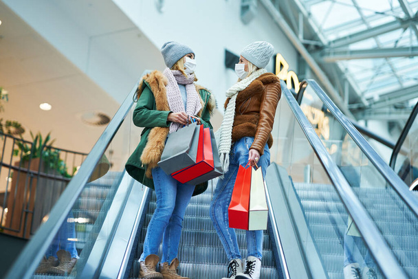 Retrato de dos amigos comprando juntos usando una máscara, concepto de coronavirus - Foto, Imagen