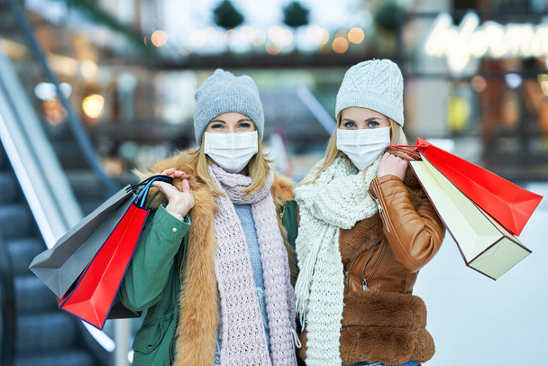 Portrait of two friends shopping together wearing a mask, coronavirus concept - Fotoğraf, Görsel