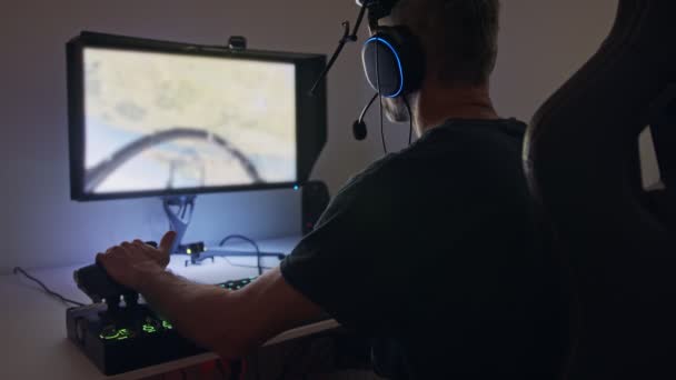 Mann spielt Flugsimulator am Computer und trägt ein Headset - Filmmaterial, Video