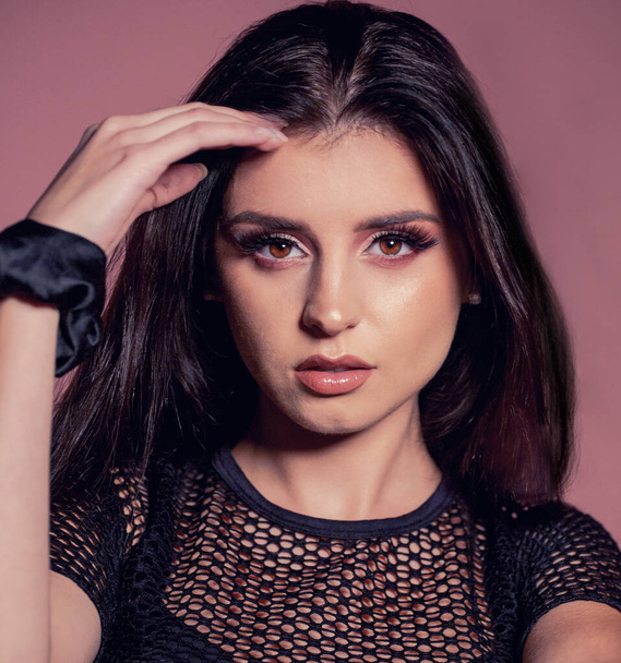 attractive brunette with pink make up on pink background - Фото, зображення