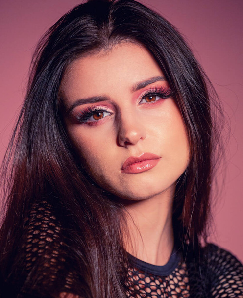 attractive brunette with pink make up on pink background - Foto, afbeelding