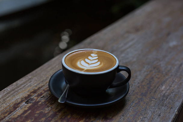 sanat latte sıcak kahve fincanı ahşap masada.  - Fotoğraf, Görsel