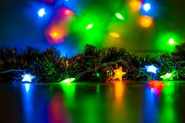 Μπάλες παιχνιδιών στο χριστουγεννιάτικο δέντρο και κώνους με πολύχρωμες γιρλάντες από κοντά. - Φωτογραφία, εικόνα