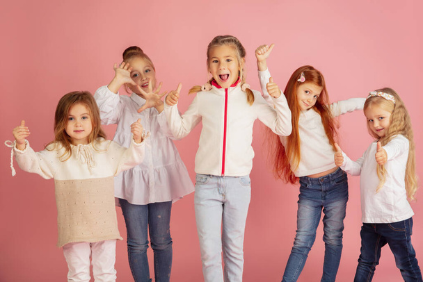 Portrait of little caucasian children with bright emotions isolated on pink studio background - Фото, зображення