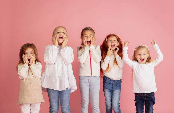 Portrait of little caucasian children with bright emotions isolated on pink studio background - Φωτογραφία, εικόνα
