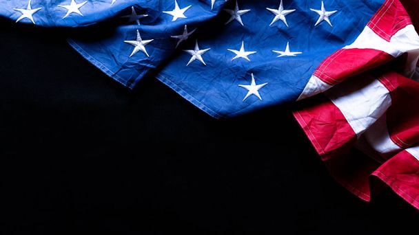 黒を背景にしたアメリカ国旗。記念、大統領、退役軍人、労働者、独立または7月4日のお祝いの日のために。トップ表示、テキストのコピースペース. - 写真・画像