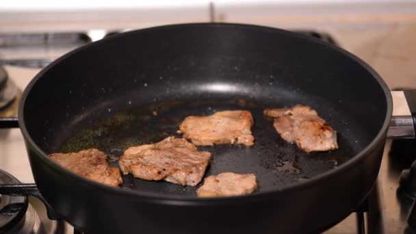 Freír trozos de carne en una sartén. Filete de cerdo asado en una sartén caliente. - Metraje, vídeo