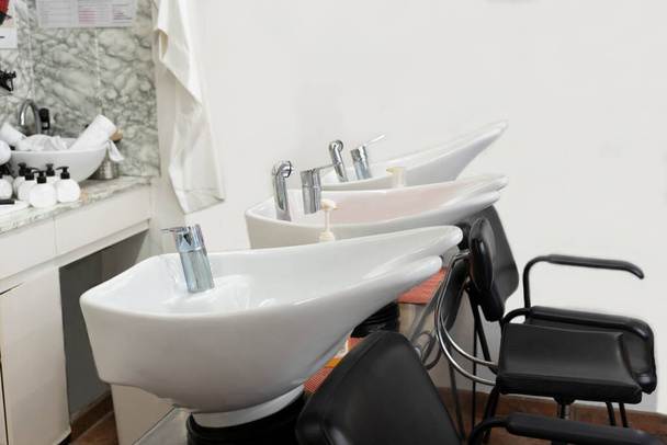 Barber shop, hairdressing salon interior.Hair wash basins chairs. Copy space text. - Photo, Image