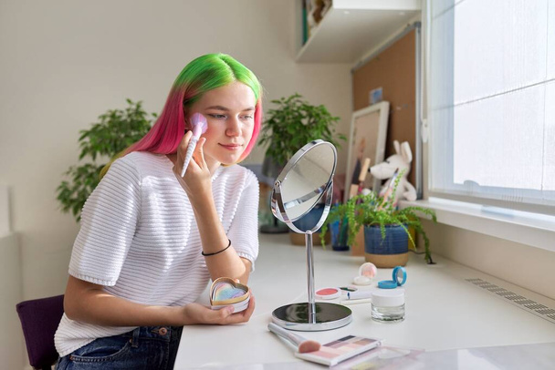 Trendy, fashionable teenager girl with dyed colored hair doing makeup - Foto, Bild
