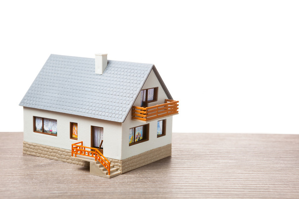 klassiek huis model op houten achtergrond - Foto, afbeelding