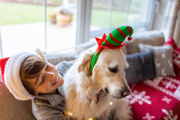 Boy and his dog enjoying Christmas together at home  - Photo, Image