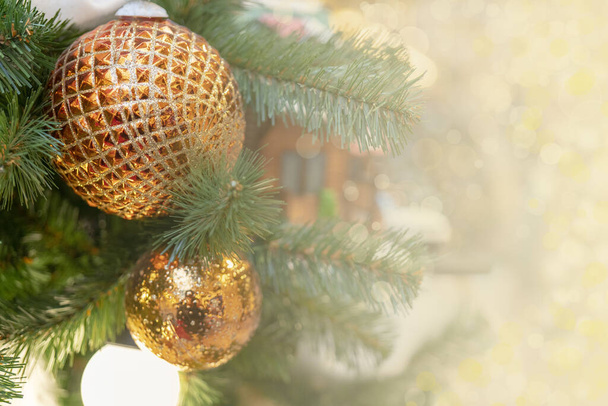 A closeup shot of golden Christmas ornaments on the Christmas tree - Фото, изображение